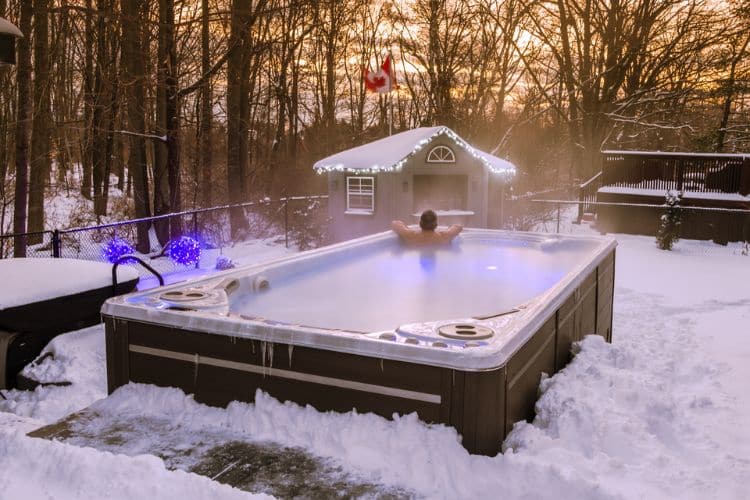 Man in Hydropool swim spa in the winter - Galaxy Home Recreation explains whether you should get a swim spa or a pool